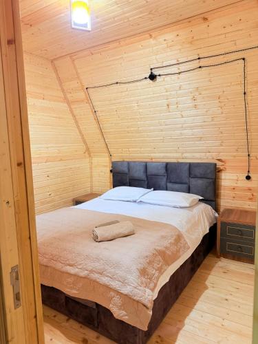 a bedroom with a bed in a wooden cabin at ჰარმონია Harmony Cottage in Ambrolauri