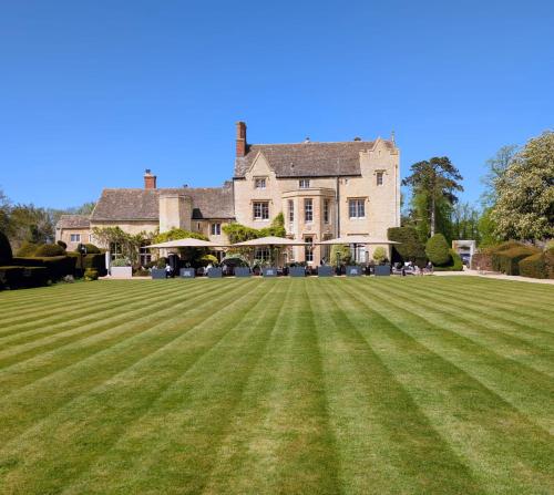 a large lawn in front of a large house at Weston Manor Hotel in Bicester