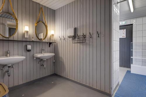 a bathroom with two sinks and two mirrors at Hraunborgir Golden Circle Tents in Kiðjaberg