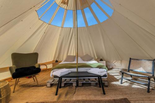 a bed and a chair in a tent at Hraunborgir Golden Circle Tents in Kiðjaberg