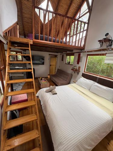a bedroom with a bunk bed and a ladder at Hospedaje La Tierrita Villa de Leyva in Villa de Leyva