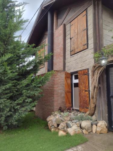 a house with a door and a pile of rocks at Lo de Adriana in Tandil