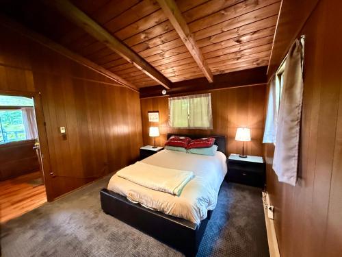 a bedroom with a bed in a room with wooden walls at Cabin on the hill Ascutney in Jenneville