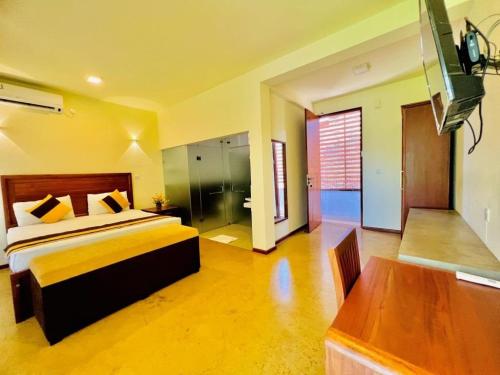 a bedroom with a bed and a table in a room at Villa Rustic in Negombo