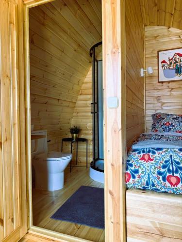 a log cabin with a bed and a toilet at LEIRIA Side Bungalow in Leiria