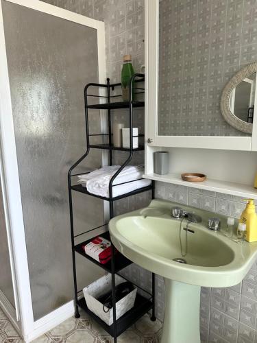 a bathroom with a sink and a shelf next to a mirror at Casiña Carreiro in Beade