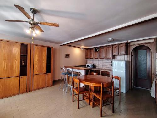 a kitchen with a dining room table and a ceiling fan at Will House in Lanzo Torinese