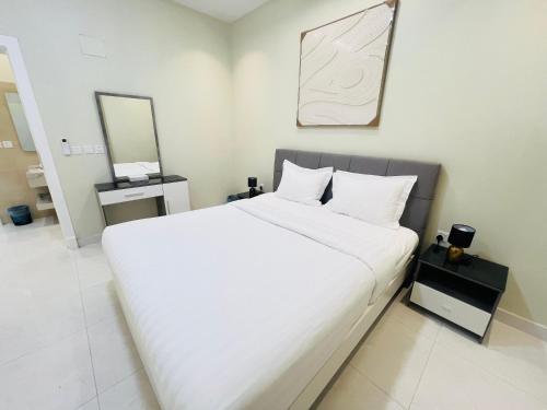 a large white bed in a room with a mirror at فـيليج سـانـسـت Village Sunset in Al Namas