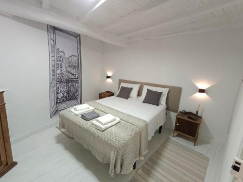 a white bedroom with two beds and a table at A Casiña do Río in Celanova
