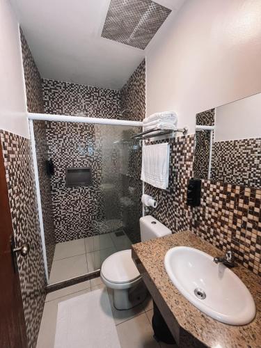 a bathroom with a toilet and a sink and a shower at Itacuruçá Inn in Itacuruçá