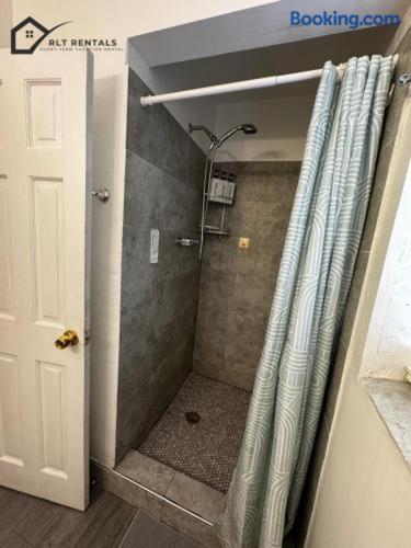 a shower with a shower curtain in a bathroom at Beautiful and Equipped Studio H in Hollywood