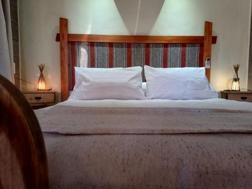 a bedroom with a large bed with white pillows at Nelumbo Petit Chalet in San Rafael