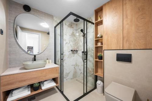 a bathroom with a shower and a sink and a mirror at Villa Olea Mandalina in Šibenik