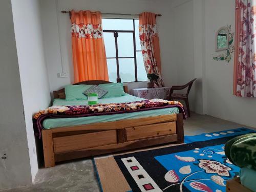 a bedroom with a bed in a room with a window at Margaret's Himalayan Nest in Kalimpong
