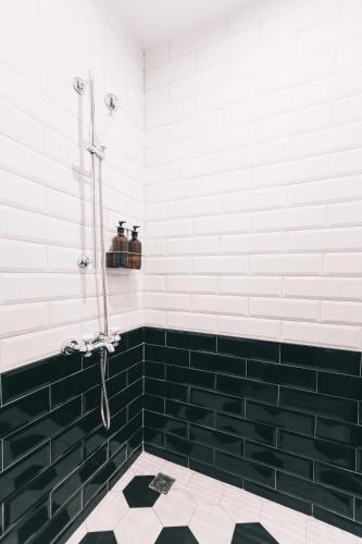 a bathroom with black and white tiles and a shower at PAPO'A Hotel in Kaohsiung