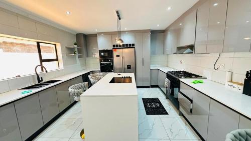 a large kitchen with white counters and appliances at The Golden Palace in Bulawayo