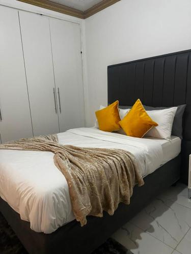 a bedroom with a large bed with yellow pillows at The Golden Palace in Bulawayo