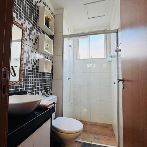 a bathroom with a toilet and a sink and a shower at Casa Valentina 2 in Catanduva