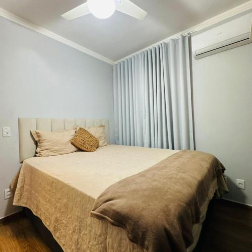 a bedroom with a bed with a large window at Casa Valentina 2 in Catanduva