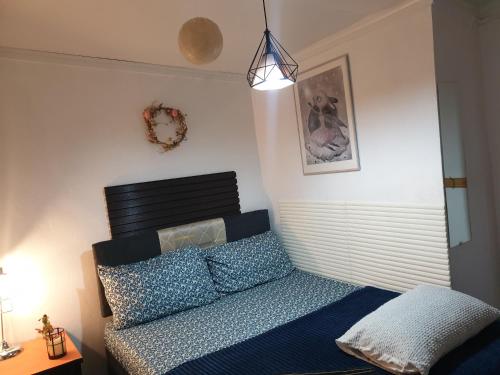 a bedroom with a bed with blue sheets and a lamp at Master's Homestay in Suva