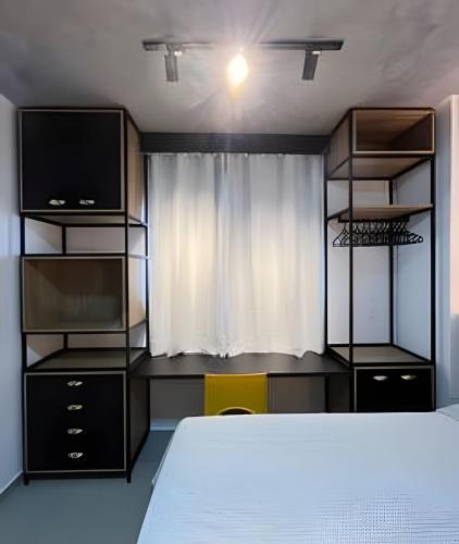 a bedroom with a bed and a tv and a window at Studio Estilo Industrial - 01 - BARRETO - in Mossoró
