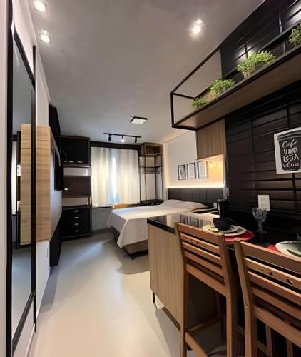 a bedroom with a bed and a table and chairs at Studio Estilo Industrial - 01 - BARRETO - in Mossoró