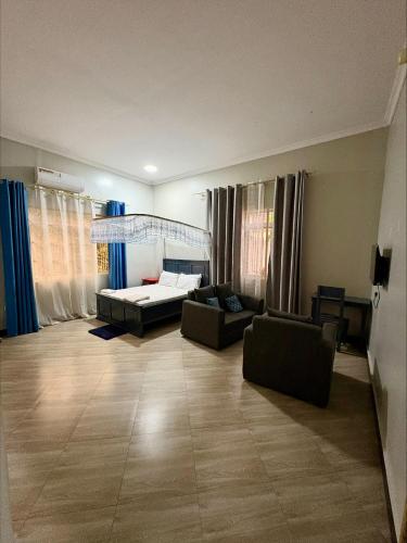 a large living room with a bed and a couch at COMFORT ZONE Lodge Kigoma in Kigoma
