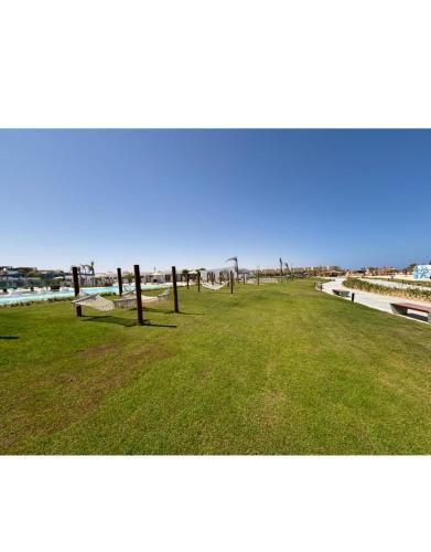 a park with green grass and wooden poles in it at D-Bay Cabin in Zāwiyat ‘Abd al Mun‘im
