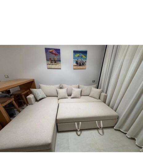 a living room with a couch and a table at D-Bay Cabin in Zāwiyat ‘Abd al Mun‘im