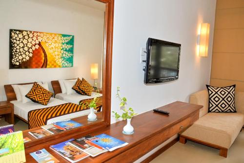 a living room with a couch and a mirror at Goldi Sands Hotel in Negombo