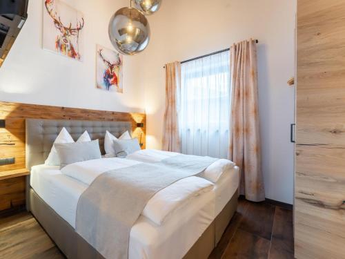 a bedroom with a large bed and a window at Tauernlodge Carpe Diem in Niedernsill