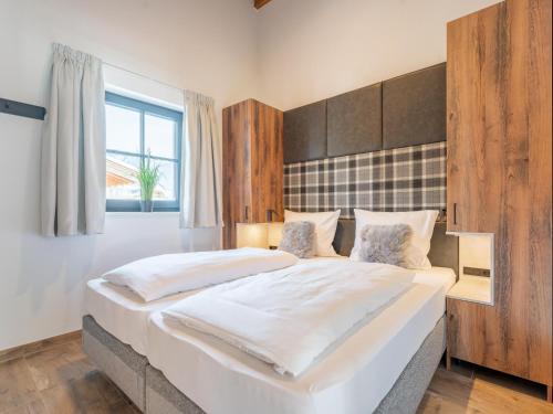 a large white bed in a room with a window at Tauernlodge Chalet Salzach in Niedernsill