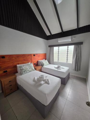 a bedroom with two beds and a window at Savusavu Terraces - Unit 1 in Savusavu
