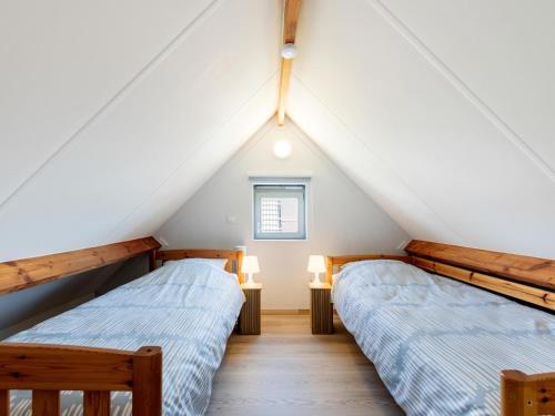 two beds in a room with a roof at Westhinder II H14 in Koksijde