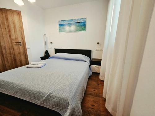 a bedroom with two twin beds and a window at Apartments by the sea Stara Novalja, Pag - 9396 in Novalja