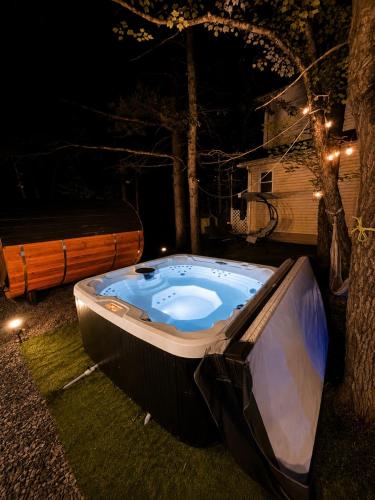 a jacuzzi tub sitting in the yard at night at Golden Deer Lodge Hot Tub Sauna Sleeps 12 in Tobyhanna