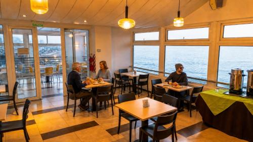 a group of people sitting at tables in a restaurant at Alto del Sol Costanera Antofagasta in Antofagasta