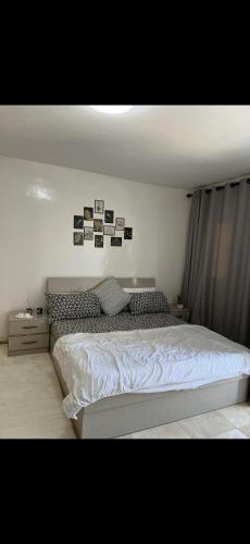 a bedroom with a white bed with pictures on the wall at Relax appartement in Nouakchott