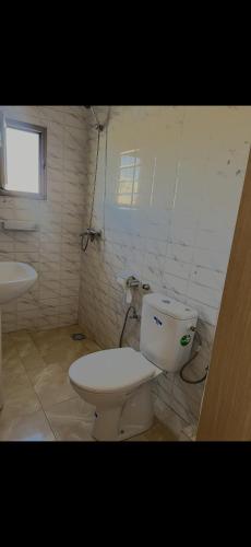 a white bathroom with a toilet and a sink at Relax appartement in Nouakchott