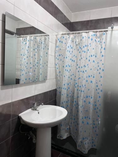 a bathroom with a sink and a shower curtain at Dardi in Peje