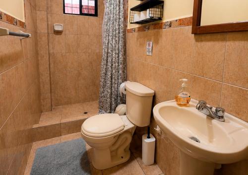 a bathroom with a toilet and a sink and a shower at Casa del Jaguar in Iquitos