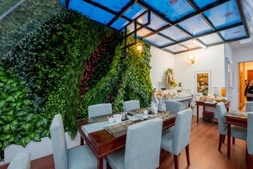 a dining room with a large green wall at Splendid Hotel & Spa in Hanoi