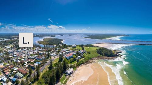 an aerial view of a beach with a sign that reads l at Surf Side - Lifestyle Yamba in Yamba