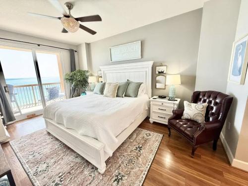 a bedroom with a large bed and a chair at Blue Heron Beach Front in Panama City Beach
