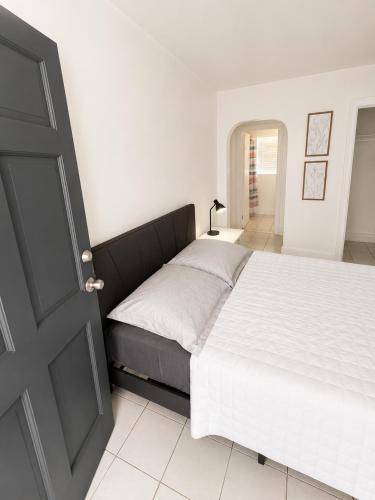 a bedroom with a bed and a black door at Comfortable Stay O in Hollywood