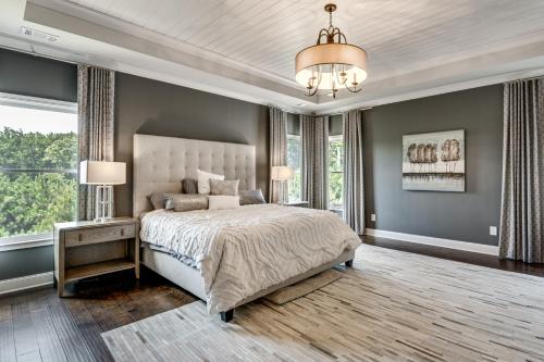 a bedroom with a large bed and a chandelier at Executive 5BR Stay in Duluth w/ Pool Access in Duluth