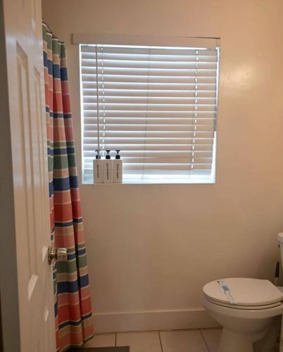 a bathroom with a toilet and a window at Comfortable Stay O in Hollywood