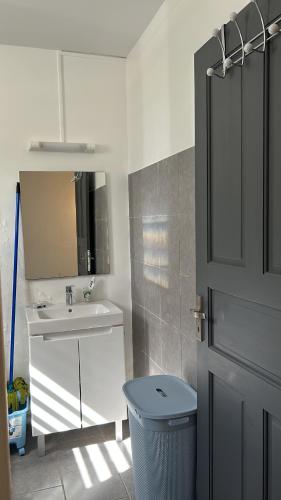 a bathroom with a sink and a toilet and a door at Villa SCAYOU in Pointe-Noire