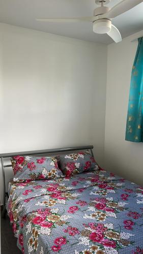 a bed in a bedroom with a floral blanket on it at Villa SCAYOU in Pointe-Noire