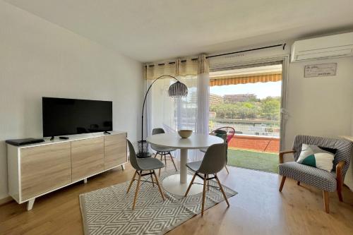 a living room with a table and a tv at Bright studio just outside Cannes in Le Cannet